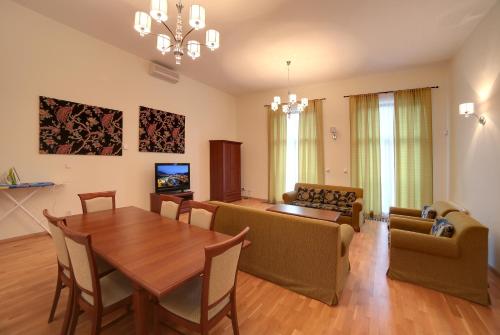 a living room with a wooden table and a dining room at Slunecni Lazne Apartments in Karlovy Vary