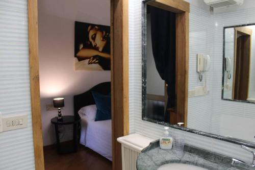 un bagno con lavandino, specchio e letto di Blue Navona Two Bedroom Apartment a Roma