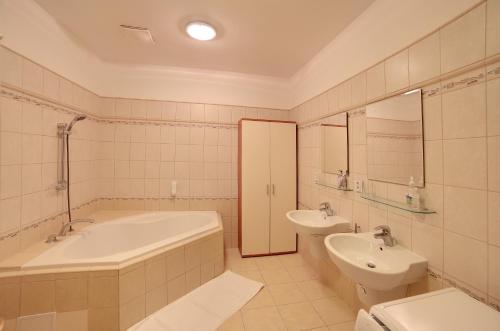 a bathroom with a tub and a toilet and a sink at Slunecni Lazne Apartments in Karlovy Vary