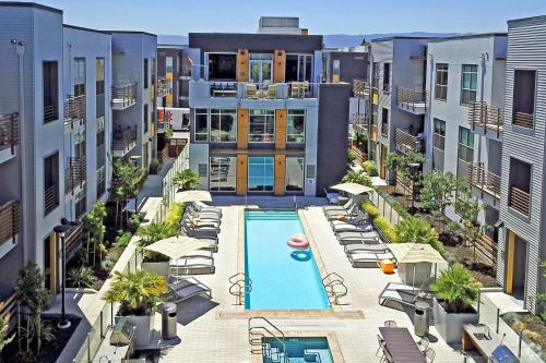 an apartment complex with a pool and chairs and buildings at Elan Menlo in Menlo Park