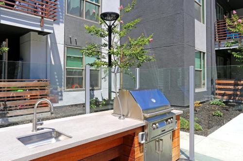 a outdoor kitchen with a grill and a sink at Elan Menlo in Menlo Park