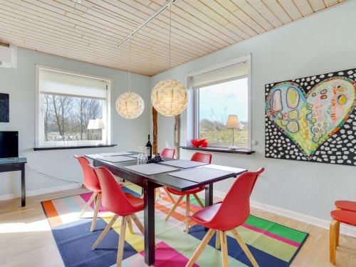 a dining room with a table and red chairs at Holiday Home Ewelina - 15km from the sea in Western Jutland by Interhome in Ballum