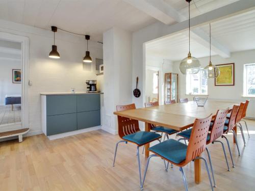 kuchnia i jadalnia z drewnianym stołem i krzesłami w obiekcie Holiday Home Guro in Western Jutland by Interhome w mieście Tønder