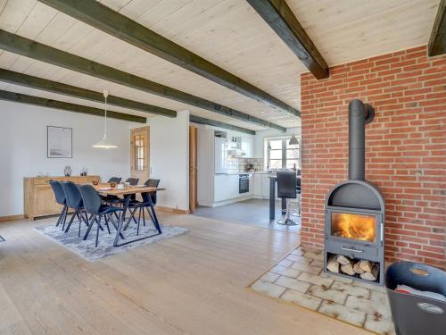 a brick fireplace in a living room with a table and chairs at Holiday Home Nita - 24km from the sea in Western Jutland by Interhome in Højer