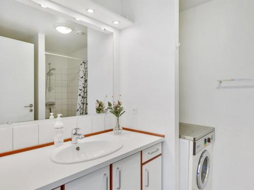 a white bathroom with a sink and a mirror at Apartment Maja - 100m from the sea by Interhome in Gråsten