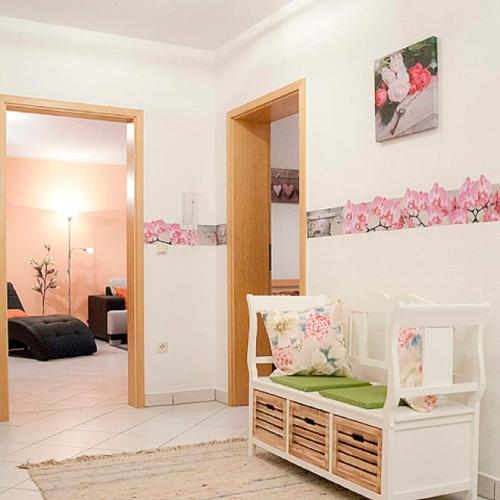 a living room with a white chair and a mirror at Ferienwohnungen Renner in Viereth-Trunstadt