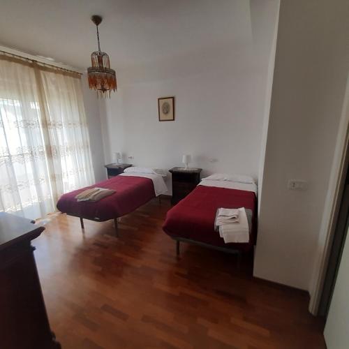 two beds in a room with wooden floors at appartamento dei pioppi in Pescara