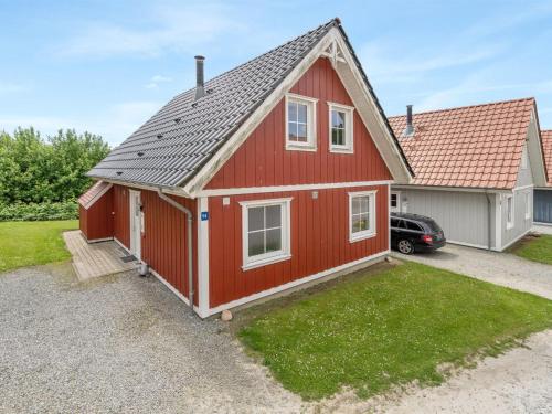 una casa roja con un coche aparcado delante de ella en Holiday Home Uffe - 200m to the inlet in SE Jutland by Interhome, en Gråsten