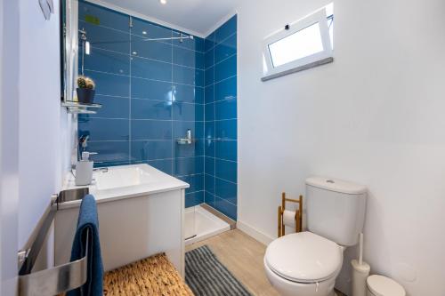 ein blau gefliestes Bad mit WC und Waschbecken in der Unterkunft Casa da Amoreira in Aljezur