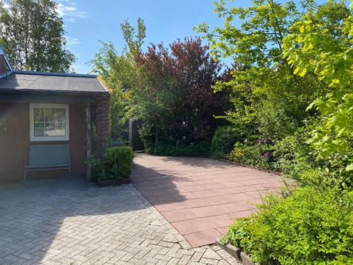 a brick driveway leading to a house with a garage at Ferienhaus Lammertshörn Bensersiel in Bensersiel