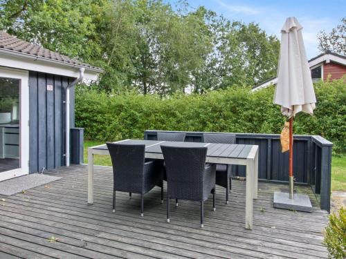 uma mesa com cadeiras e um guarda-sol num deque em Holiday Home Gurly - 25km from the sea in Western Jutland by Interhome em Toftlund