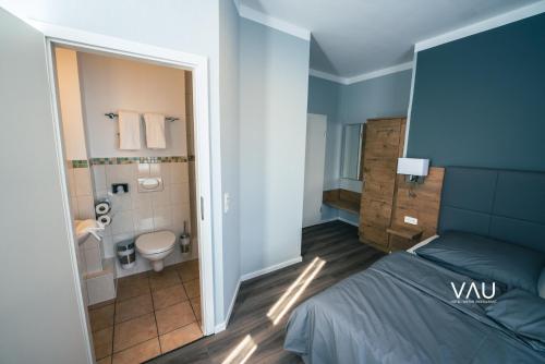 a bedroom with a bed and a bathroom with a toilet at Vau in Stuttgart