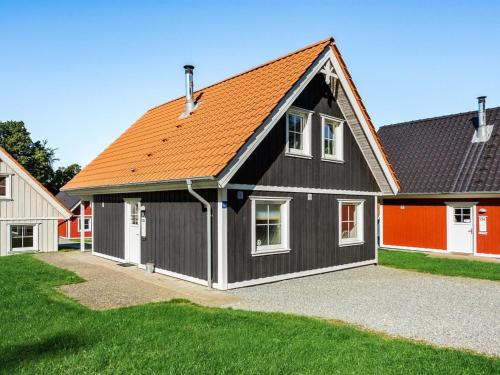 ein schwarzes Haus mit orangefarbenem Dach in der Unterkunft Holiday Home Joris - 100m to the inlet in SE Jutland by Interhome in Gråsten