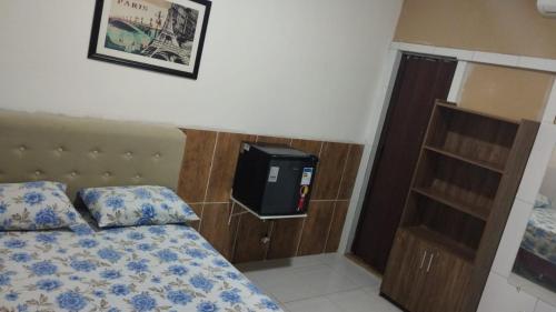 a bedroom with a bed and a tv on the wall at Cantinho Nativus in Maragogi