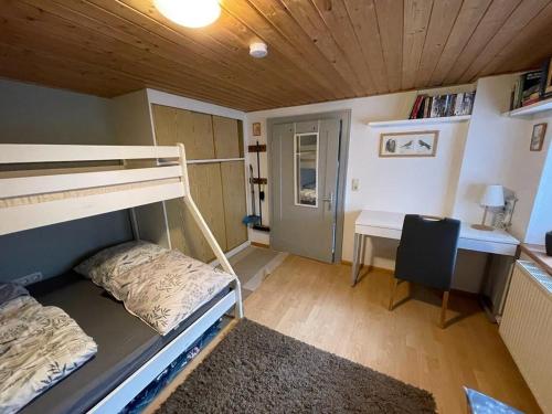 a small room with a bunk bed and a desk at Kiwi Ferienwohnung in Bludenz
