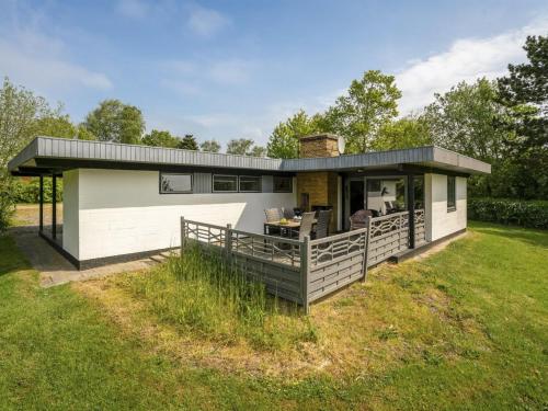 a small house with a deck on a lawn at Holiday Home Yak - 350m from the sea by Interhome in Sønderby