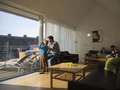 a man is holding a child in a living room at Apartment Dilruba - 2-4km from the sea in Western Jutland by Interhome in Havneby