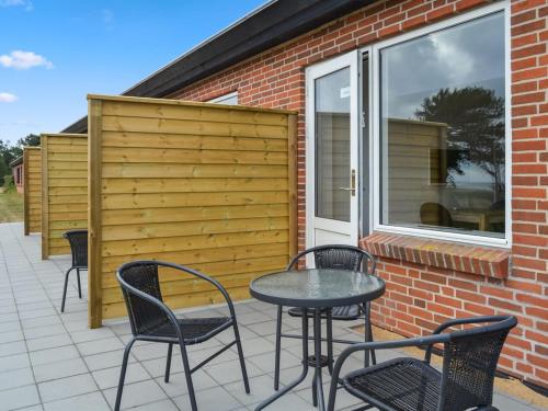 een patio met stoelen, een tafel en een hek bij Apartment Annicka - 5km from the sea in Western Jutland by Interhome in Kongsmark