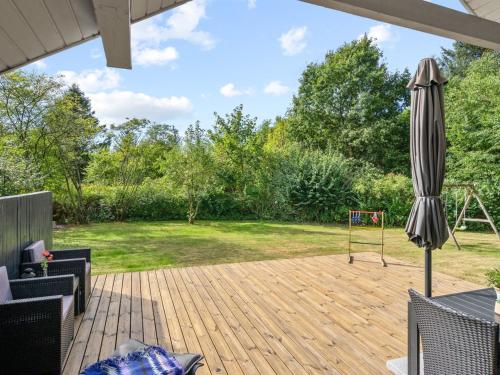 a patio with an umbrella and a playground at Holiday Home Pance - 20km to the inlet in Western Jutland by Interhome in Toftlund