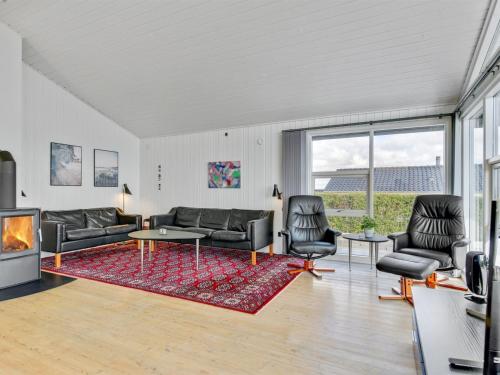 a living room with a couch and chairs and a fireplace at Holiday Home Beowulf - 200m from the sea by Interhome in Broager