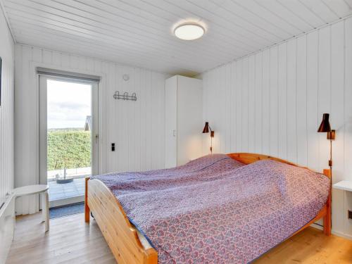 a bedroom with a bed and a large window at Holiday Home Beowulf - 200m from the sea by Interhome in Broager