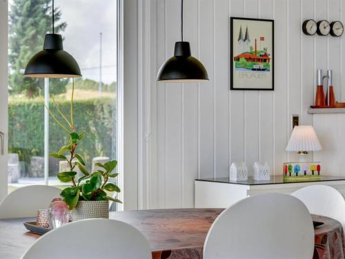 a dining room with white chairs and a table at Holiday Home Beowulf - 200m from the sea by Interhome in Broager
