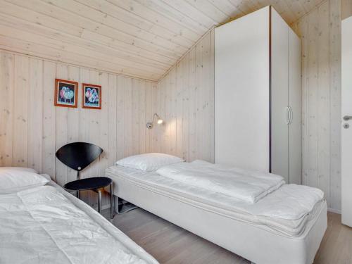 a bedroom with two beds and a cabinet and a chair at Holiday Home Juliana - 400m from the sea by Interhome in Nordborg