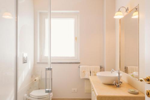 bagno con lavandino, servizi igienici e finestra di VILLA AGA a Noli