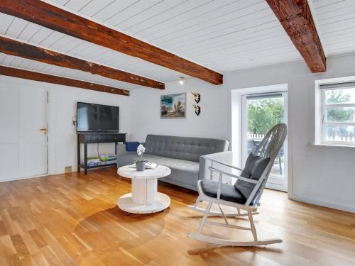 ein Wohnzimmer mit einem Sofa und einem Stuhl in der Unterkunft Holiday Home Miko - 19km from the sea in Western Jutland by Interhome in Skærbæk