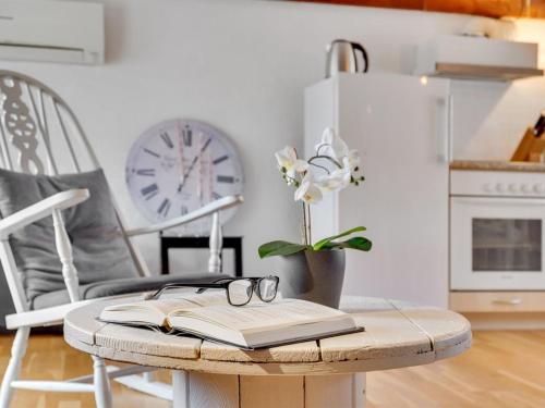 a table with an open book and a clock in a kitchen at Holiday Home Miko - 19km from the sea in Western Jutland by Interhome in Skærbæk