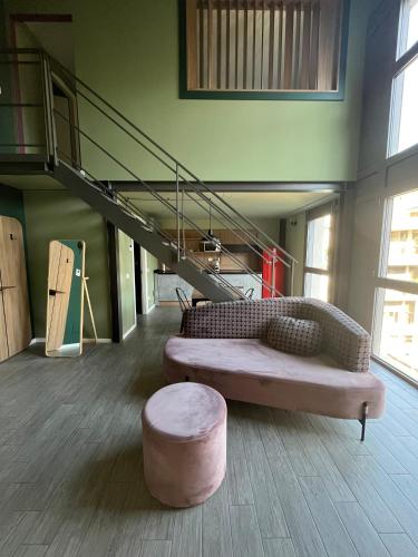 a living room with a couch and a stool and a staircase at Unico Studios in Milan