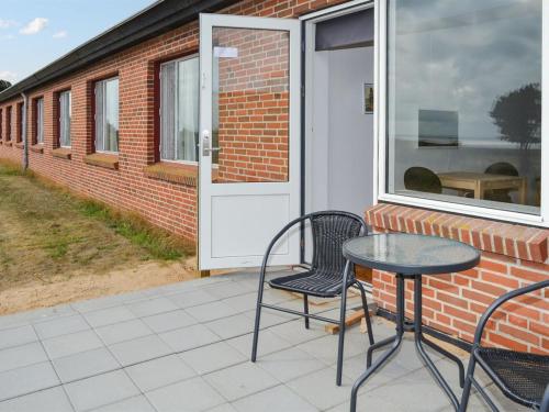 eine Terrasse mit 2 Stühlen, einem Tisch und einer Tür in der Unterkunft Apartment Baltser - 5km from the sea in Western Jutland by Interhome in Kongsmark
