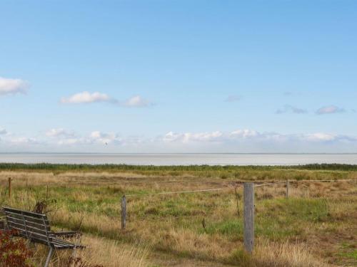 a fence in a field with the ocean in the background at Apartment Baltser - 5km from the sea in Western Jutland by Interhome in Kongsmark
