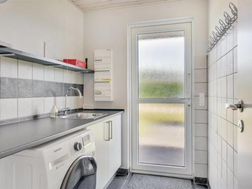 a kitchen with a sink and a washing machine at Holiday Home Damiana - 500m from the sea by Interhome in Sarup