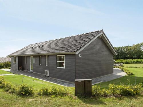 a small house with a gray roof at Holiday Home Damiana - 500m from the sea by Interhome in Sarup