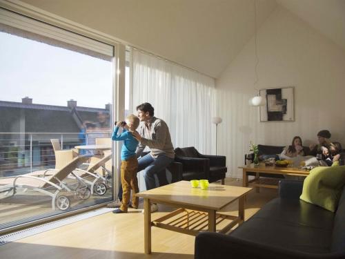 a man holding a child in a living room at Apartment Aapeli - 2km from the sea in Western Jutland by Interhome in Sønderby