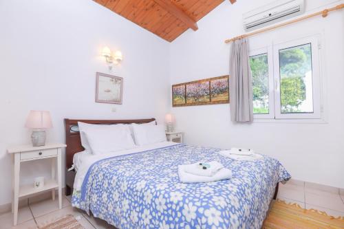 グリファダにあるSuzanne's Apartment Glyfada Menigos Resortのベッドルーム1室(青と白の掛け布団付きのベッド1台付)