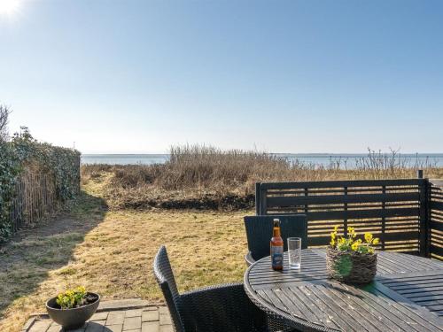 a table and chairs with a bottle of beer on it at Apartment Herkko - 25m from the sea in Western Jutland by Interhome in Esbjerg