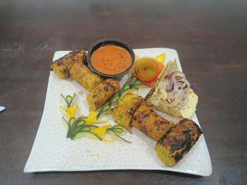 a plate of food with dipping sauce on a table at Hotel Mirana , Tinsukia in Tinsukia