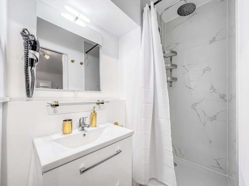 a white bathroom with a sink and a shower at Bright studio in the center of Montreux in Montreux