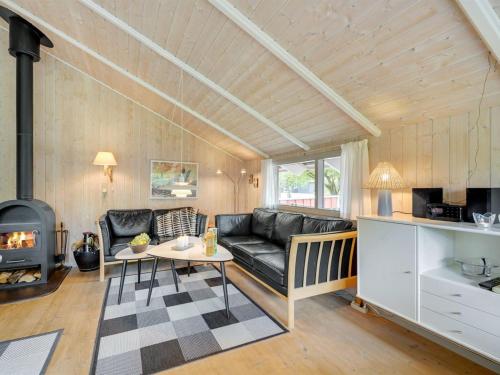 sala de estar con sofá negro y chimenea en Holiday Home Danna - 850m to the inlet in Western Jutland by Interhome, en Hemmet