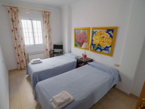 Habitación con 2 camas y ventana en Nerja Paradise Rentals - Villa Las Brisas, en Nerja