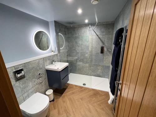 een badkamer met een toilet, een wastafel en een douche bij La Sagesse in Windermere
