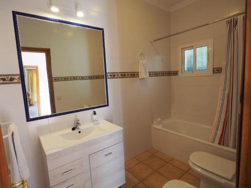 Nerja Paradise Rentals - Villa Los Girasoles في نيرخا: حمام مع حوض وحوض ومرآة