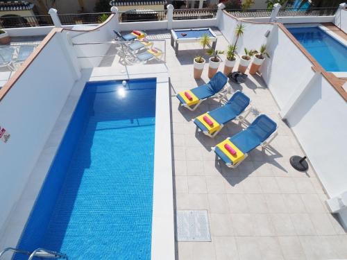 an overhead view of a swimming pool with chaises and chairs at Nerja Paradise Rentals - Villa Dos Ardillas in Nerja