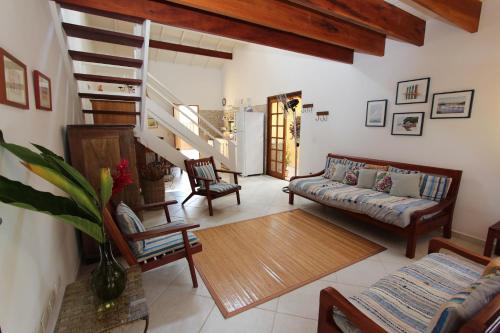 Casa 32 Paraty في باراتي: غرفة معيشة مع أريكة وكراسي وسلالم