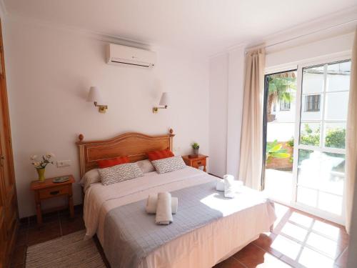 een slaapkamer met een bed en een groot raam bij Nerja Paradise Rentals - Villa Jazmines in Nerja
