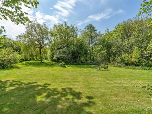 a park with a bench in the middle of a field at Holiday Home Birita - 20km from the sea in Western Jutland by Interhome in Ribe
