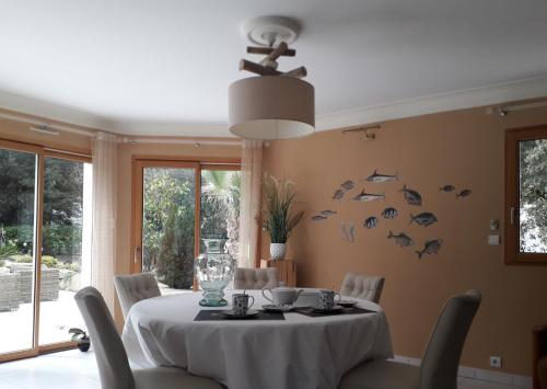 une salle à manger avec une table et des poissons sur le mur dans l'établissement Belle de Dune, à La Baule