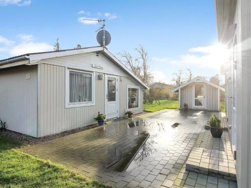 un pequeño edificio blanco con un patio junto a una casa en Holiday Home Pyry - 400m to the inlet in Western Jutland by Interhome en Skjern